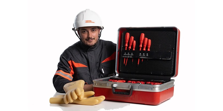 Tehnician Rețele Electrice cu echipament de protecție și trusă de scule izolată pentru intervenții sigure.