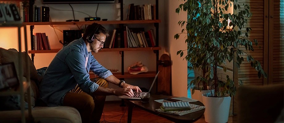 Barbat care lucrează concentrat pe laptop.