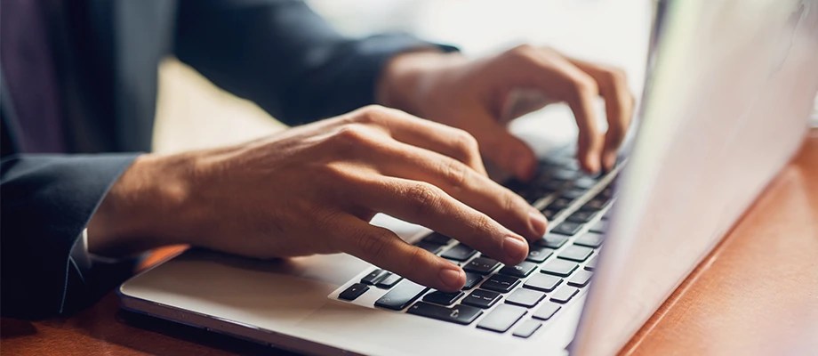 Persoană care lucrează pe laptop. Compensații în cazul întreruperilor de energie.