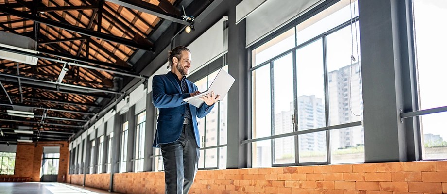 Real estate developer checking grid connection plans on a laptop.