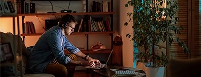 Bărbat care lucrează de acasă, într-un living modern.