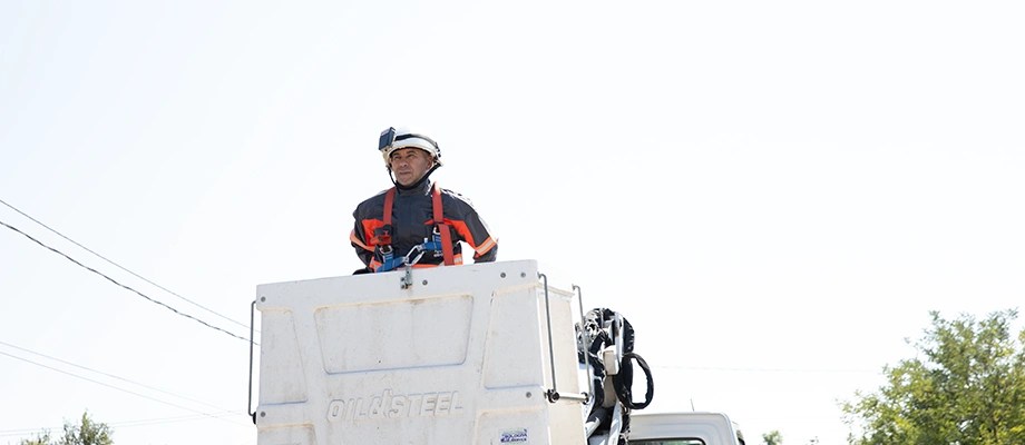 Tehnician în echipament de protecție care lucrează la mentenanța rețelelor electrice.