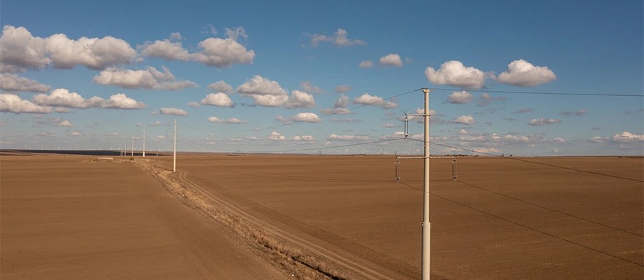 Stâlpi de electricitate instalați într-o zonă rurală pentru extinderea rețelei electrice.