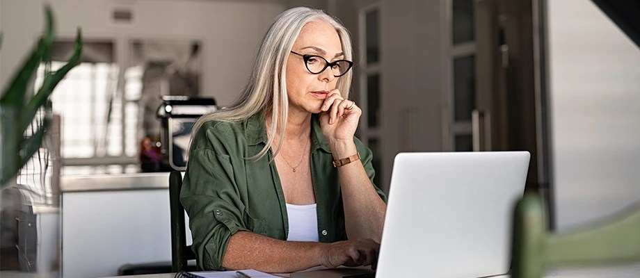 Femeie care lucrează pe laptop.