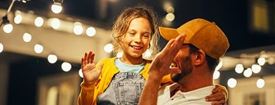 Tată și fiică sub lumini de exterior.