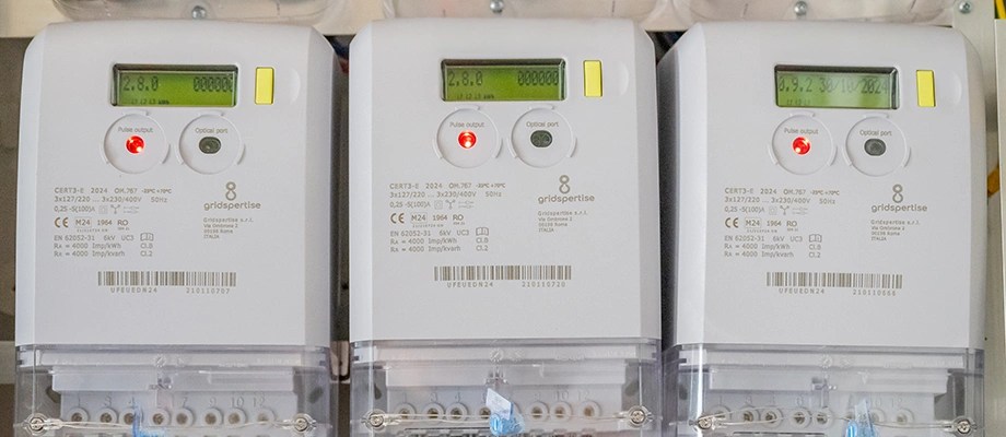 Grup de trei contoare electrice digitale instalate într-un panou electric.