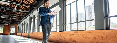 Bărbat într-un spațiu luminos care folosește un laptop pentru a accesa informații despre prosumatori.