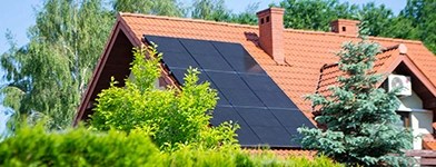 Casă modernă cu panouri solare montate pe acoperiș, utilizând energie regenerabilă.