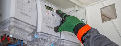 Tehnician verificând sau instalând un contor inteligent de energie electrică.