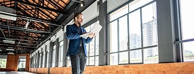 Inginer verificand infrastructura electrica intr-o cladire industriala moderna