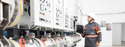 Tehnician care monitorizează echipamente de înaltă tensiune într-o stație de transformare.