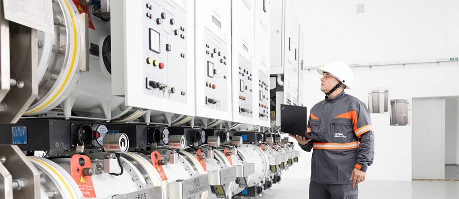 Tehnician care monitorizează echipamente de înaltă tensiune într-o stație de transformare.