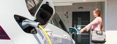 Mașină electrică în curs de încărcare acasă.